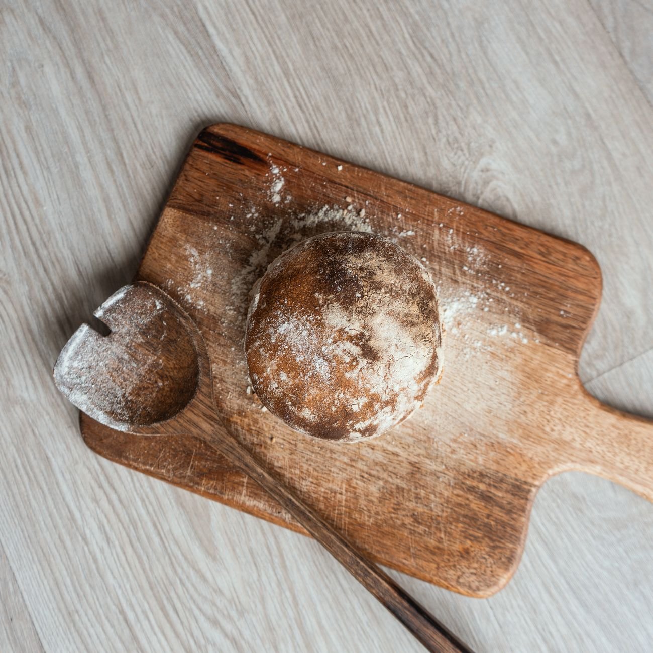 Freshly baked rustic bread on a wooden cutting board — artisan kitchen photography